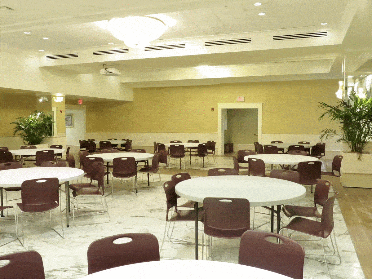 a hall with round tables surrounded by chairs